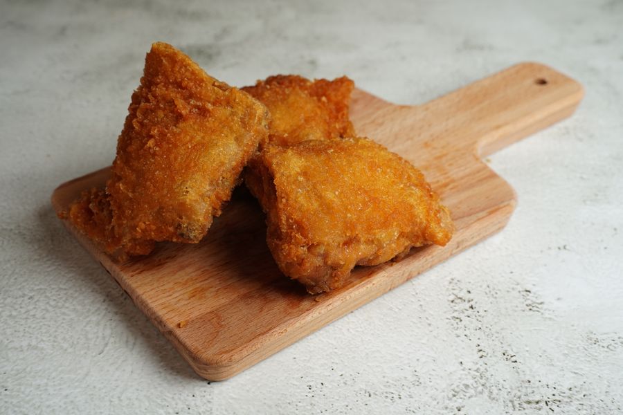 Crispy fried chicken pieces on a wooden board