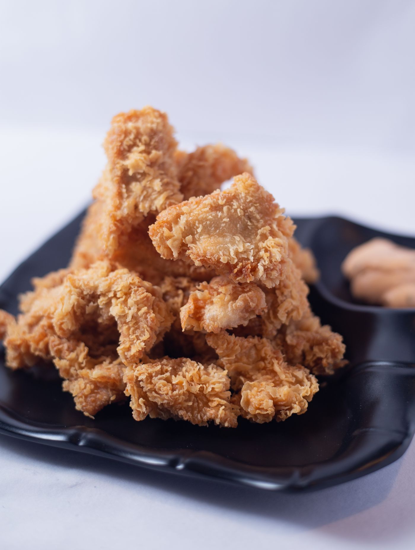 Crispy fried chicken pieces stacked on a plate